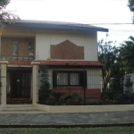 Casa semi mobiliada de 3 dormintórios, sendo 2 suites. Ampla área social e íntima,  living três ambientes com lareira, lavabo, sala de estar e jantar integrada a área da churrasqueira. Pátio com pisci