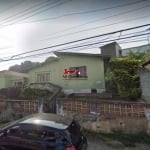 Terreno com generosos 303 m², acompanhado por uma casa antiga, em um terreno em aclive.