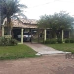 Casa de material  com chapa em Imbé com três dormitórios sendo uma suite , sala de estar com lareira e jantar conjugadas , area de serviço , patio cercado . . Quiosque , pergolado e canil . Apto para 