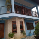 Casa com 5 dormitórios sendo deles 4 suítes no centro de Guaíba.&lt;BR&gt;Sobrado com peças amplas e iluminadas, living, sala com lareira, sala de tv, sala de jantar, 5 dormitórios sendo 4 suítes, 3 s