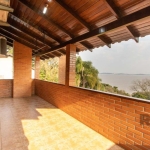 Ótima casa em tijolo á vista com 3 dormitórios, sendo 2 suítes, a suíte principal com hidro massagem, com sacada e linda vista para o lago Guaíba, banho social, living 2 ambientes em desnível com lare