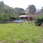 Sítio com cerca de 1,3 hectares, acesso por estrada asfaltada, com casa de alvenaria com duas suítes, sala com lareira, cozinha com fogão à lenha, piscina, lavabo, gás central, três churrasqueiras, ca