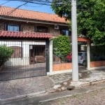 Casa no Bairro Cavalhada com 5 dormitórios, 4 banheiros, sala, cozinha, churrasqueira com fogão campeiro em área interna fechada, duas vagas de garagem com possibilidade de três, pátio na frente e atr