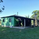 Casa de alvenaria com 2 dormitórios, sala e cozinha conjugado e churrasqueira na varanda.