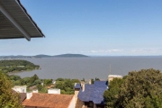 Excelente casa com a mais deslumbrante vista do Guaiba, não estamos exagerando.&lt;BR&gt;Imóvel em níveis com lances curtos de escada, living com sacada vista panorâmica do rio, integrado a grande cop