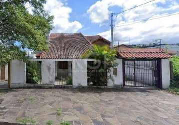 Casa diferenciada com grades e portão automático para a garagem, 2 pavimentos, no térreo, ampla sala com colunas, cozinha, lavanderia, sala com lareira, acesso a garagem, 1 dormitório e banheiro. para