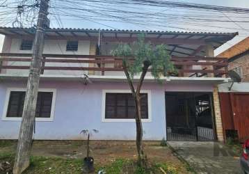 Casa com 2 pavimentos, sendo 2 casas independentes, sendo a parte superior com 2 dormitórios, banheiro social, sala de estar e jantar com lareira, integradas a cozinha, área externa com churrasqueira 