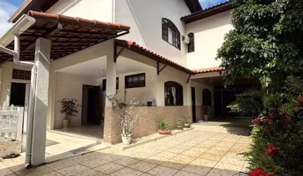 Casa com fachada imponente colonial, possuindo 2 fênix na calçada.