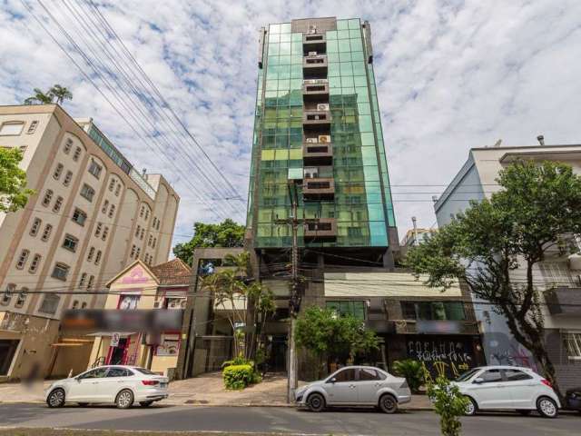 Sala comercial à venda ou locação no bairro Menino Deus, em Porto Alegre, com uma vaga de garagem coberta e escriturada. Situada na parte dos fundos laterais do prédio, a sala oferece um ambiente tran