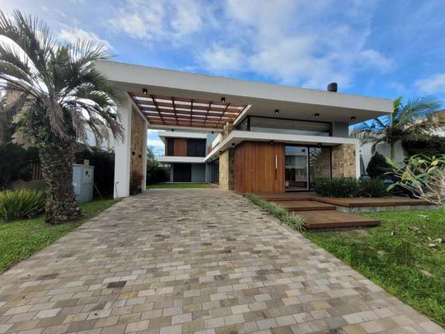 Esta espetacular casa de alto padrão, localizada no prestigiado Condomínio Villagio Xangri Lá, é uma verdadeira joia em Xangri-Lá. Com 4 dormitórios, 4 suítes e 5 banheiros sociais, esta residência of