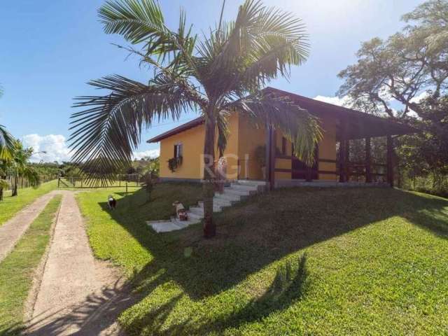 Sítio em Belém Novo, cercado - com casa de 3 dormitórios, sala living 2 ambientes, lareira, copa/cozinha, banheiro, lavanderia e garagem para 6 carros cobertos. Espaço com árvores frutíferas e estufa.