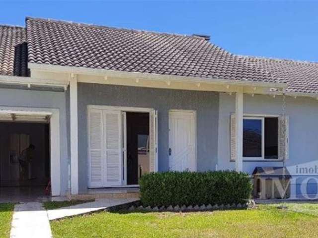 Casa de alvenaria com três quartos, sala, cozinha com lareira, banheiro social, área de serviço com churrasqueira e garagem  para dois carros e banheiro. Piso laminado nos quartos e cerâmico na demais