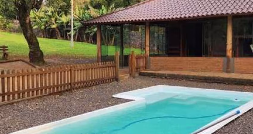 Casa com 2 dormitórios, piscina em terreno totalmente arborizado.
